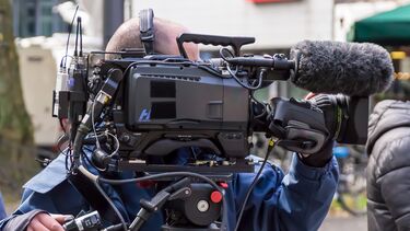 A man operating a video camera.