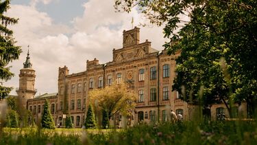 A grand building at the KPI campus in Kyiv, before the war with beautiful green gardens and trees