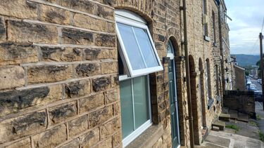 The front of a house with a ground level window slightly open