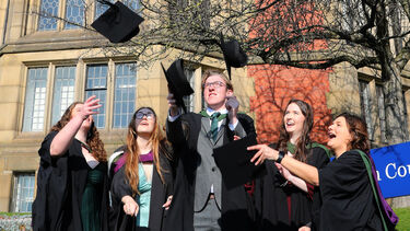 Postgraduates throwing hats outside