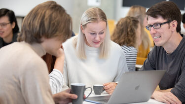 three researchers sat in a cafe working together