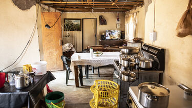 The inside of a house showing kitchen equipment and dining table