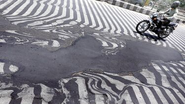 Distorted concrete with a motorbike driving over it.