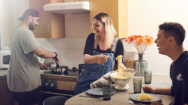 Three students in accommodation in the kitchen cooking