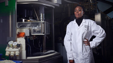Chemical and Biological Engineering student in a lab coat in the lab