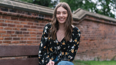 Caroline Jo Lilley sitting on a bench outside Bartolome House