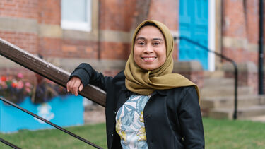 Photo of Dwi Martini in front of Bartolome House