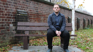 Harry Imlack sitting on a bench outside of Bartolome House