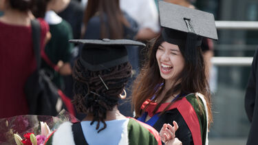 Graduate smiling with another graduate