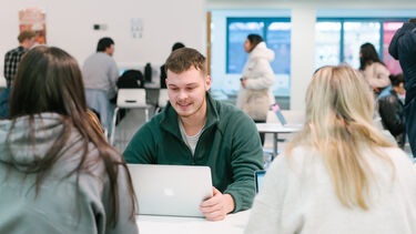 A student with a laptop in the cafe.