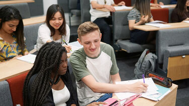 Undergraduate students working together in a lecture theatre.