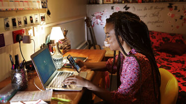Student at home typing on laptop