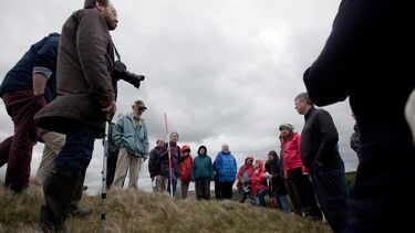 A large group meeting outdoors for a festival with some cloudy weather. The shot is taken from low down.