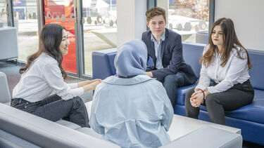 Students sat on sofas socialising.