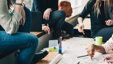 A group study session with students gathered around a table.