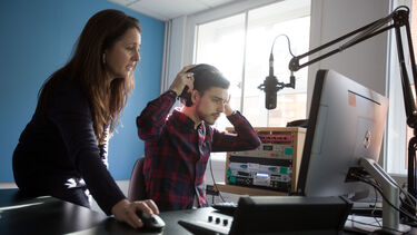 Two people using audiovisual equipment