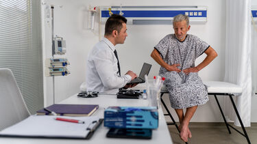 Doctor listens intently to a senior male patient