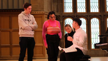 Groups of students talking on stage