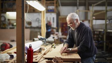 Older male with grey hair doing woodwork