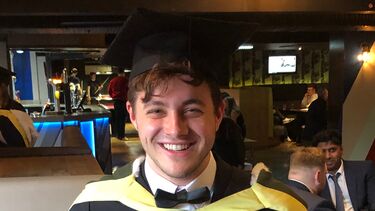 Jonathan Wright wearing graduation robes.