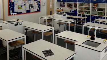 Photograph of school classroom with empty desks and chairs