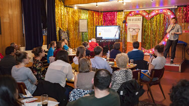 An academic delivering a Pint of Science talk to a room of people
