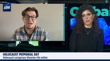 A man and a woman in a TV news studio. The news ticker at the bottom of the screen reads: Holocaust memorial day. Holocaust conspiracy theories rife online