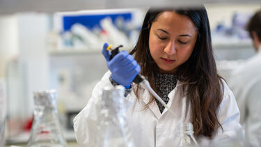 Researcher in a lab using a pipet