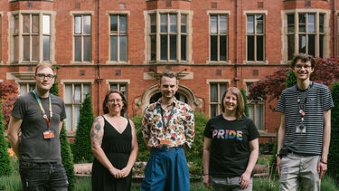 Five people stood in front of heritage building