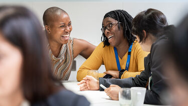 two colleagues smiling and laughing at conference