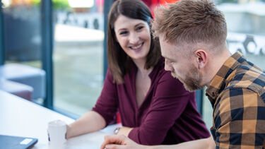 2 students together working on a tablet.