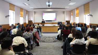 Back of the moot court in a lecture theatre style layout filled with attendees of a lecture on gender and sexuality