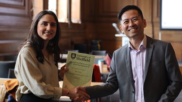 Photograph of Ece and Head of Department Professor Chee Hing Tan, taken as Ece receives an award at the Department's Student Experience Awards