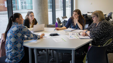 Group of students in discussion around a table
