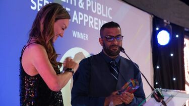 A man in a suit delivers an award acceptance speech.