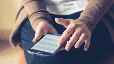 close up of hands scrolling on a smartphone