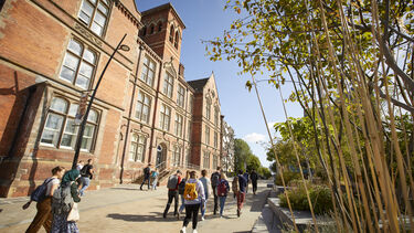 Students walking on the University's campus surrounded by trees