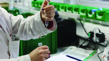 A lab technician using an injector
