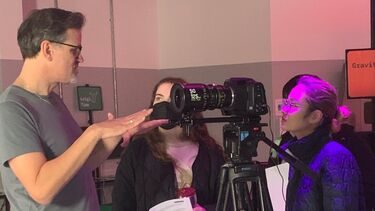 Staff showing students how to use camera