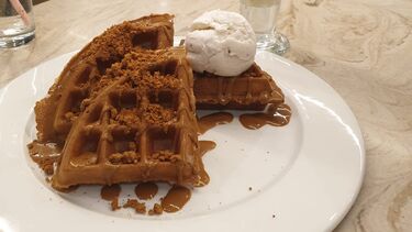 Waffles topped with ice cream, toffee sauce and crumbled Biscoff.