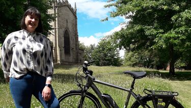 A photo of a senior member of University staff with a Try B4U Buy e-bike