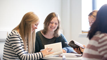 Two students smiling and looking happy