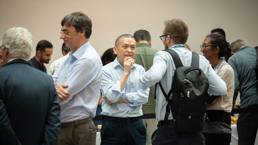 People standing talking at an event