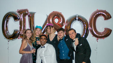 A group of people standing in front of balloons that read CIV SOC