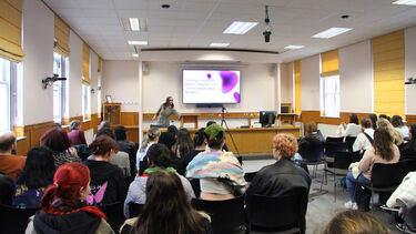 Presenter at the front of the moot court with the moot court in the style of a lecture theatre. Room is filled with an audience.