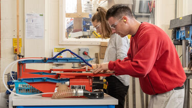 Two students using the facilities in the workshop as part of their induction