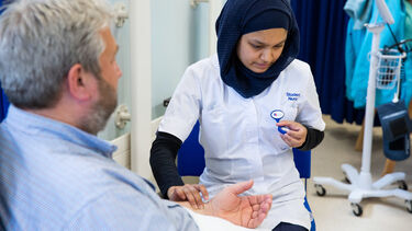 A student nurse monitoring a patient