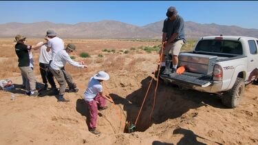Photo showing the recovery team pulling the upper stage of the rocket out of the ground