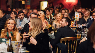 image of people sat at tables at awards ceremony 