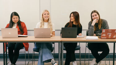Postgraduate Law students with laptops sat at a table
